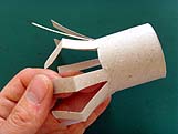 Pliage des languettes en carton vers le haut puis vers le bas pour donner du relief aux pattes de l'araignée.