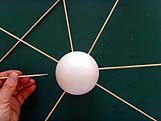 Insertion des piques à brochette dans la boule de polystyrène pour la toile d'araignée.